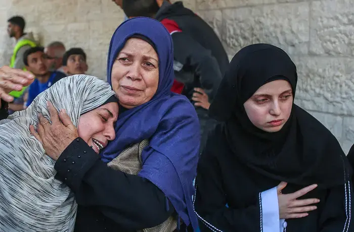 Palestinian women grieve over the bodies of their relatives who were killed in Israeli bombings in Nuseirat and Deir al-Balah, in the central Gaza Strip.
