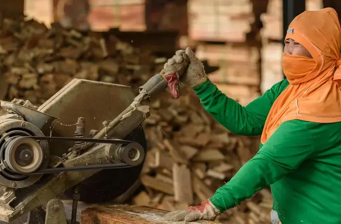 A migrant woman worker cuts timber in a sawmill in Nakhon Nayok, Thailand, around 50 kilometres north-east of Bangkok. Photo: UN Women/Pornvit Visitoran