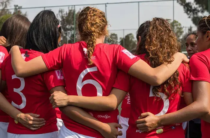 A group of girls huddle together before a football match in Mexico as part of the first HeForShe Lightning Tournament 